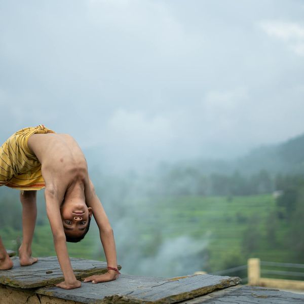 Person in a calm stretching pose against a natural, serene background.